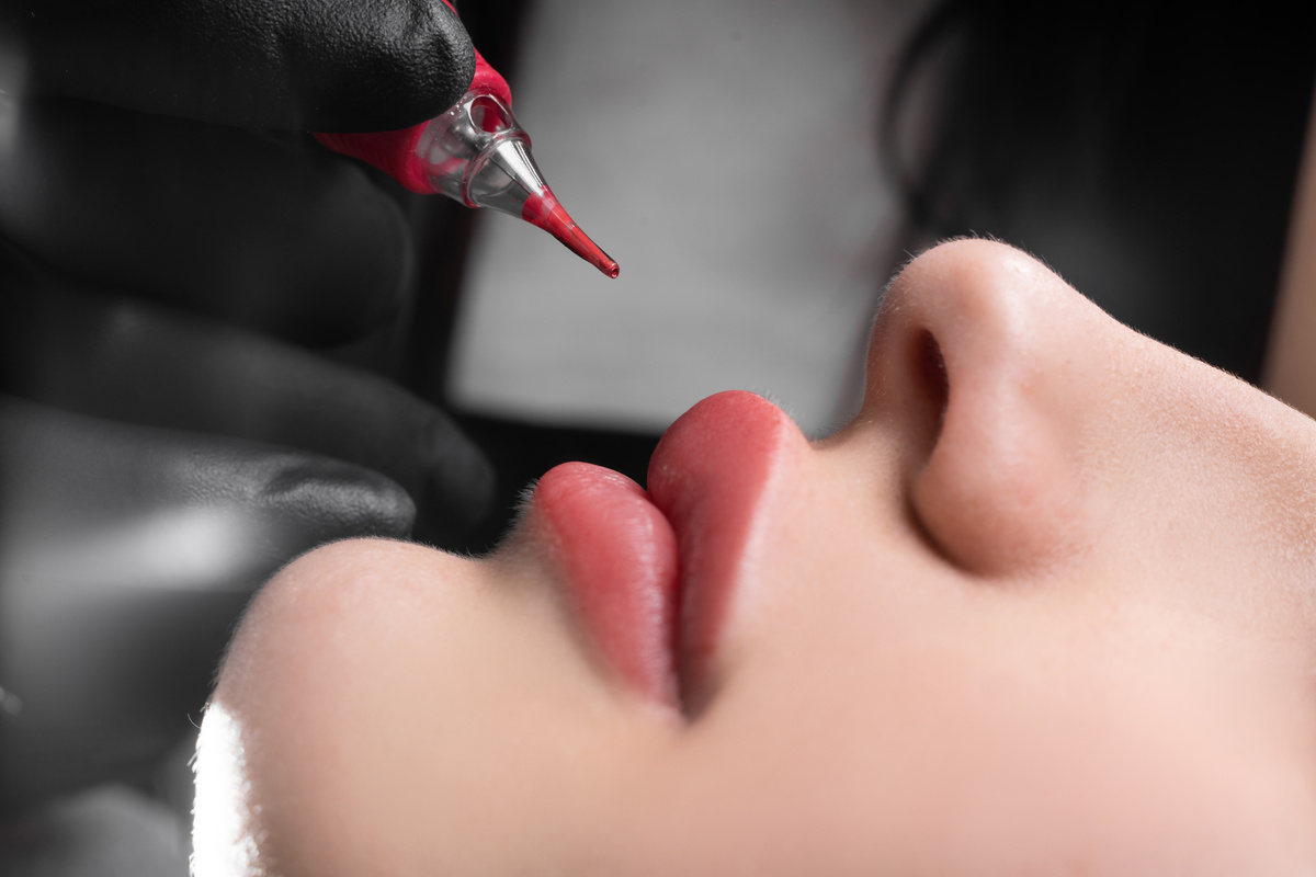 permanent lip makeup in a beauty salon, lip tattoo with coloring pigment, beautiful female lips